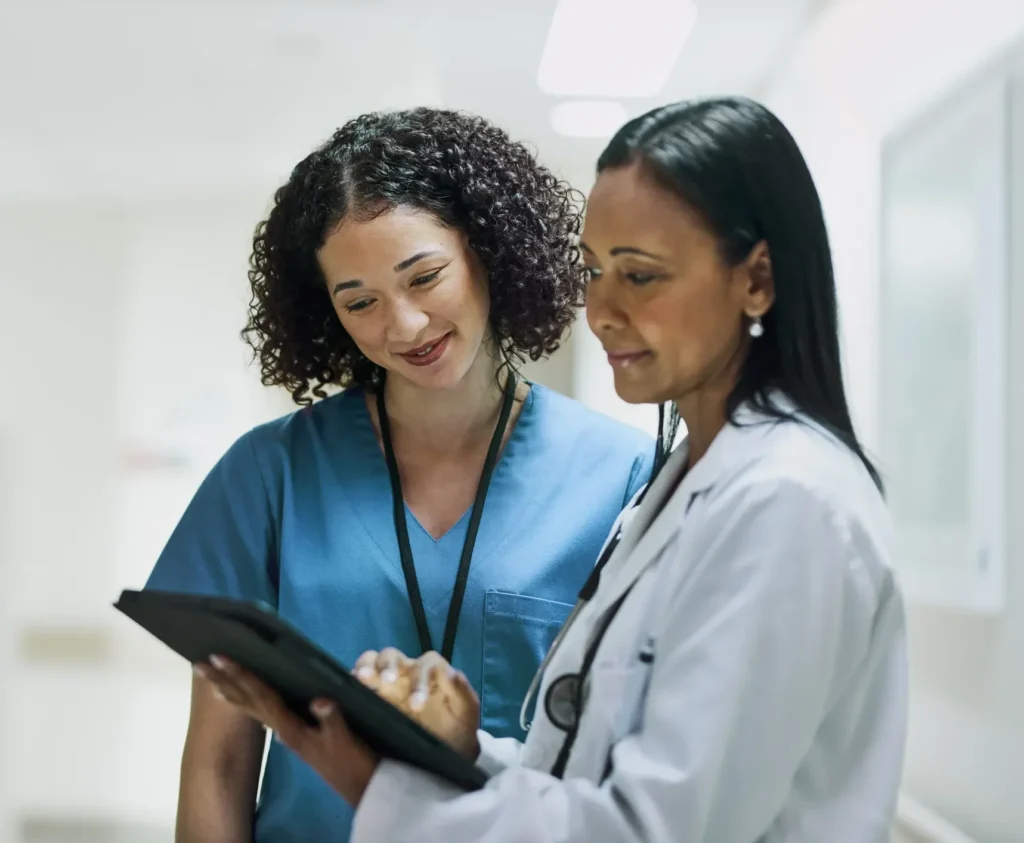 two nurses reading from a tablet