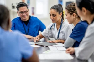 a group of nurses discussing documents on a table