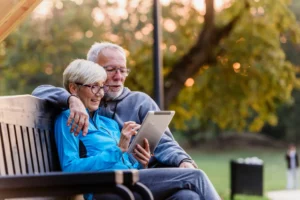 senior couple reading watching reading from a tablet and embracing each other