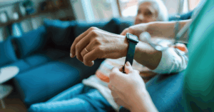 Caregiver puts a wristband wearable monitor on a patient