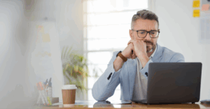 Healthcare CIO evaluating patient monitoring systems on laptop in modern office