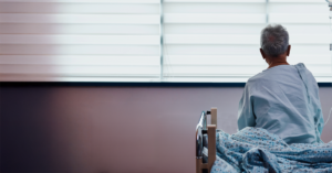 A patient preparing to get out of bed, exemplifying a focus on preventing fall and pressure injuries.