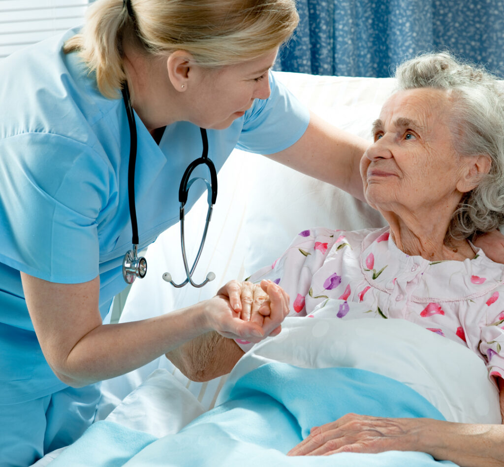 Nurse holding hand of elderly resident in skilled nursing facility, supporting post-acute care
