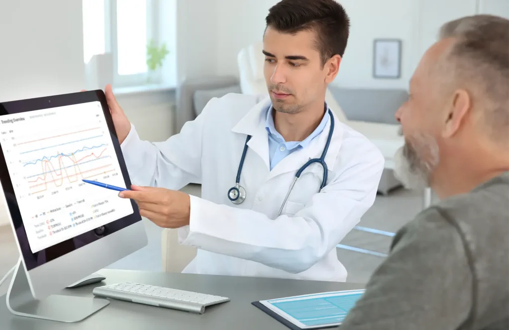 Male pulmonologist shares respiratory rate data from continuous monitoring with male patient during an office visit.
